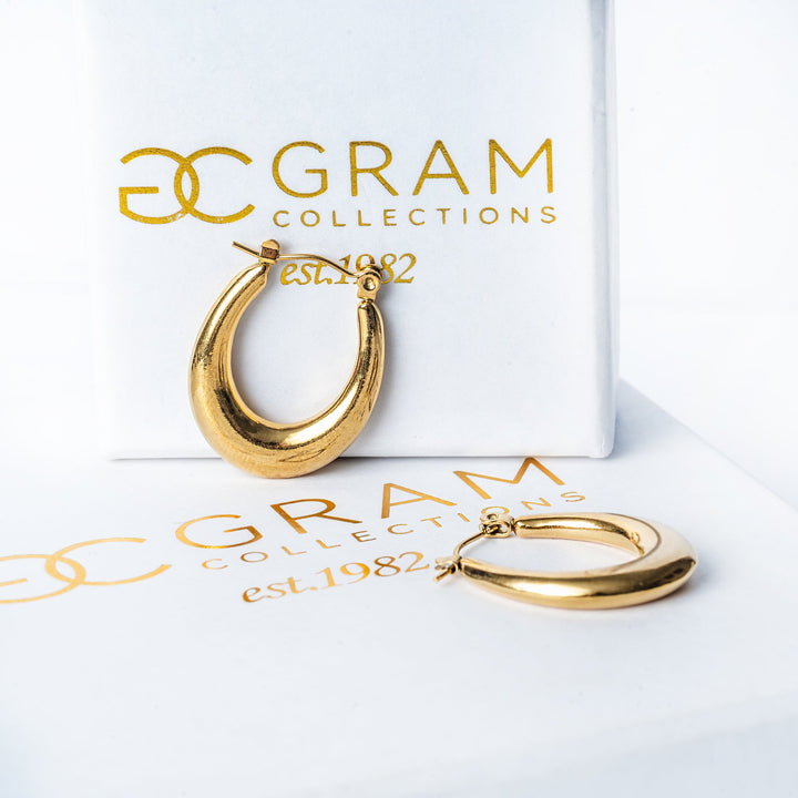 Sandra Gold Earrings placed on its uniquely designed white box. 