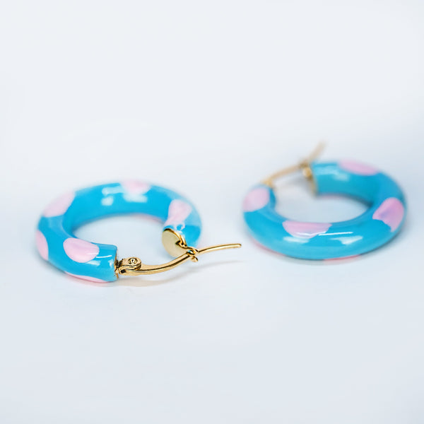 A pair of sea earrings with blue and pink colors, gold plating, and stainless steel construction, displayed against a white background.
