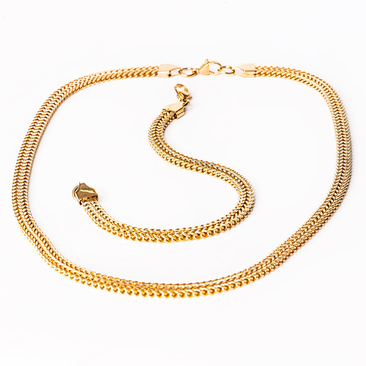 A close up view of sienna gold set consist of bracelet and necklace standing in the center of the image against a white background. 