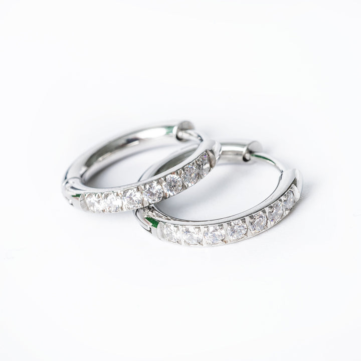 A close up view of a Sharm silver earring against a white background. 