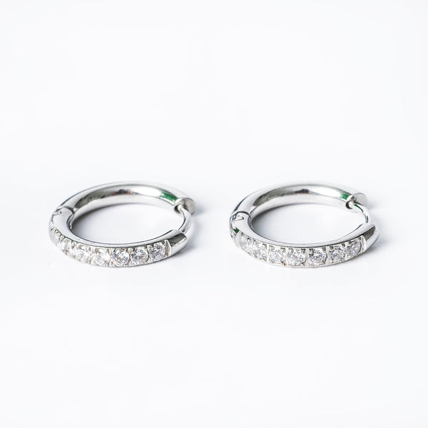A pair of silver hoop earrings with cubic zirconia embellishments.