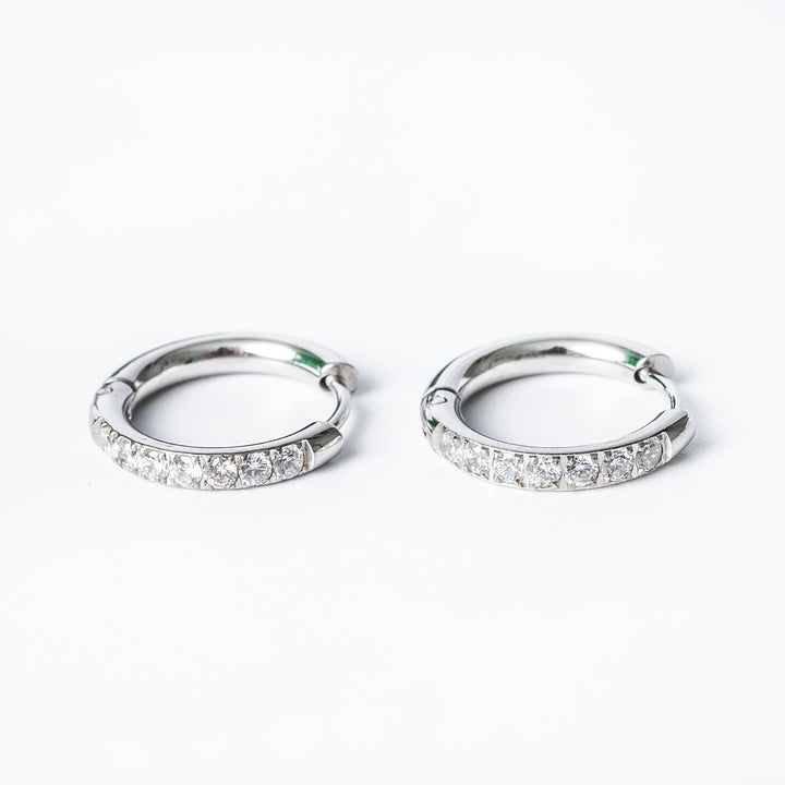 A pair of silver hoop earrings with cubic zirconia embellishments.