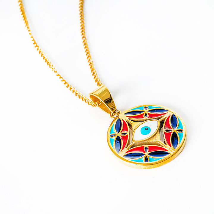 A side view of Ghajn pendant necklace with a gold chain on a white background