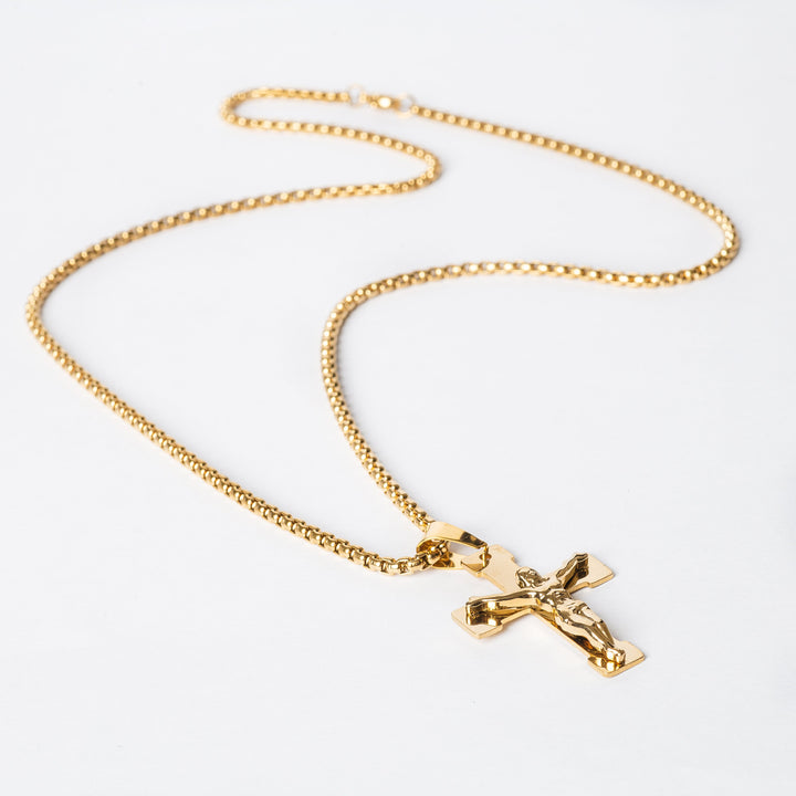 Side view of gold necklace placed in the center of the image. 
