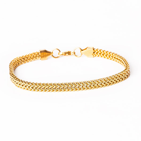 A yellow gold stainless steel bracelet with a solid pattern and a clasp closure.