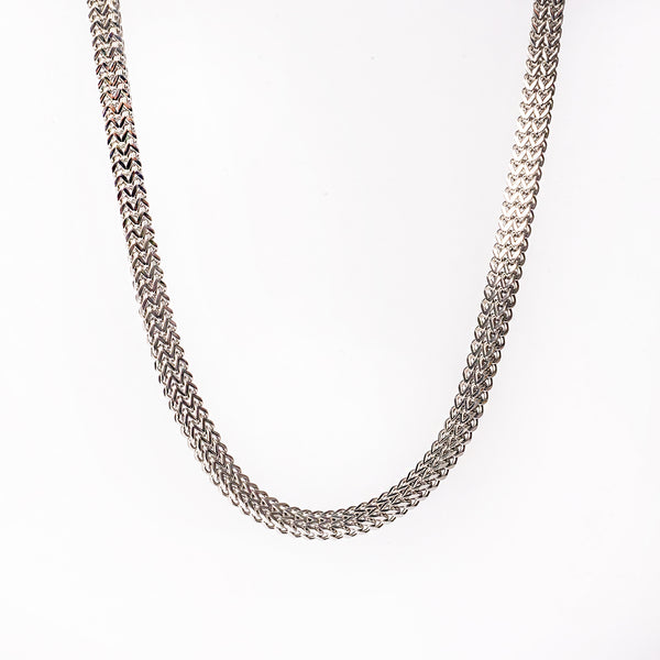 A silver stainless steel necklace with a geometric pattern, displayed against a white background.