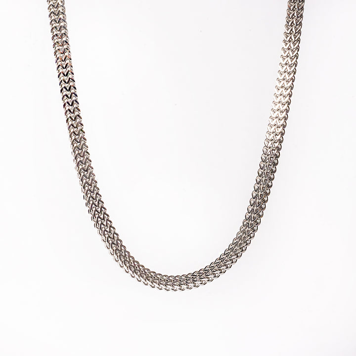 A silver stainless steel necklace with a geometric pattern, displayed against a white background.