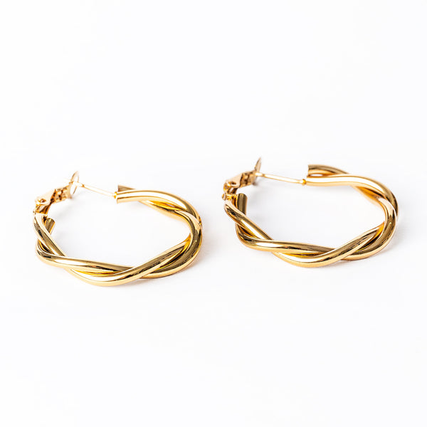 A pair of yellow gold stainless steel Solane hoop earrings with a textured surface, displayed against a white background.
