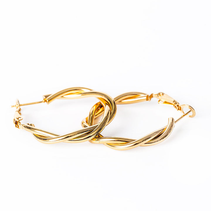 A close up view of Solange Earrings standing on top of each other in the center of the image against a white background. 