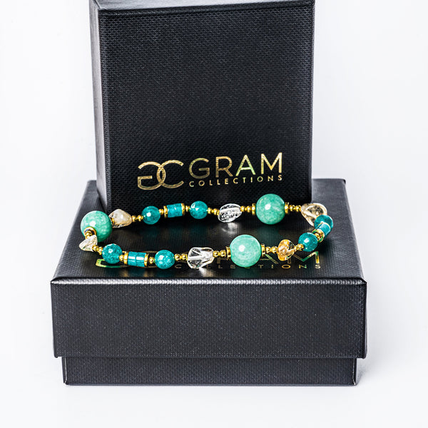 Spring bracelet standing on top of its box surrounded by a white background. 
