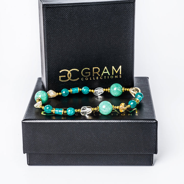 Spring bracelet standing on top of its box surrounded by a white background. 