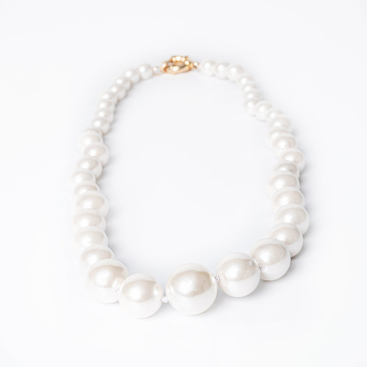 A white pearl Starlight necklace with yellow gold plating and a gold-colored chain.