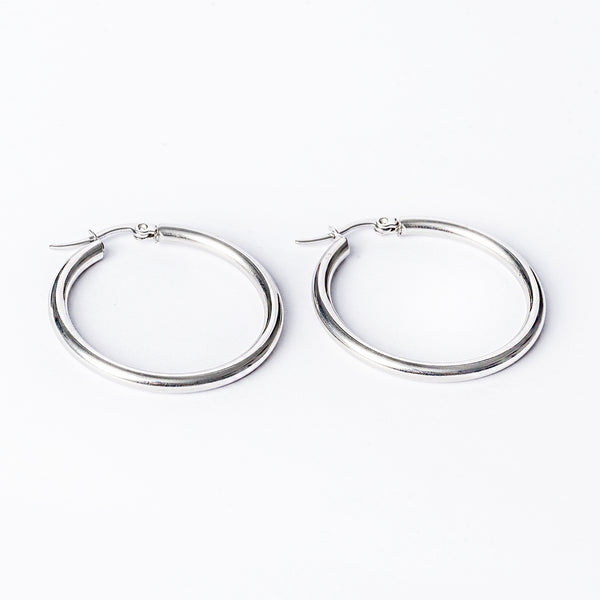 Stefania silver earrings standing in the center of the image against a white background. 