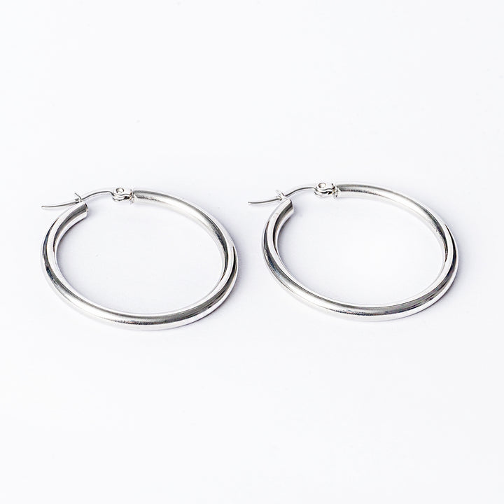 Stefania silver earrings standing in the center of the image against a white background. 