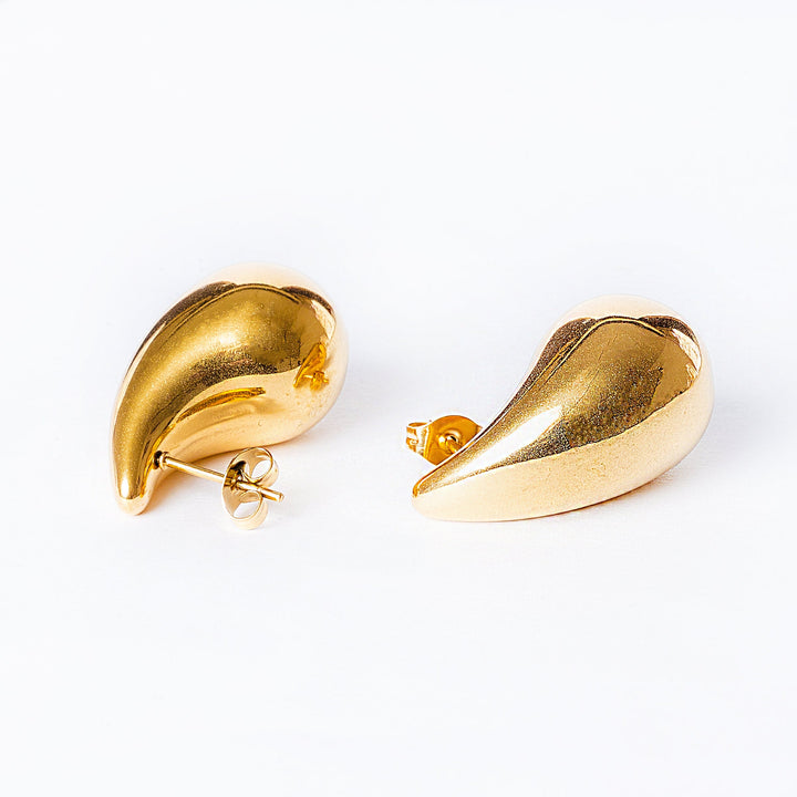A pair of gold-plated stainless steel hoop earrings on a white background.