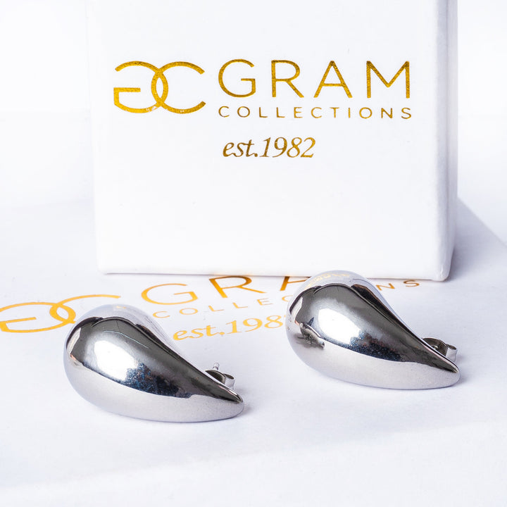 Stella earrings placed on its box viewed from the side. 