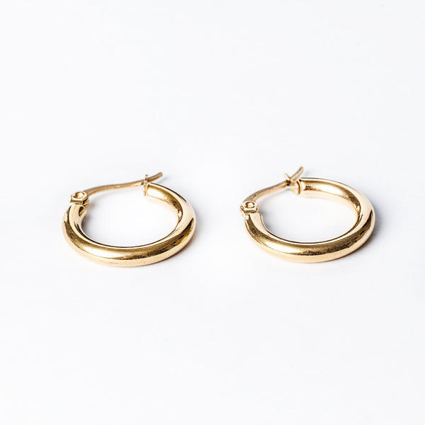 A pair of yellow gold hoop Svetlana earrings with a hyperallergenic and tarnish-free stainless steel body, displayed against a white background.
