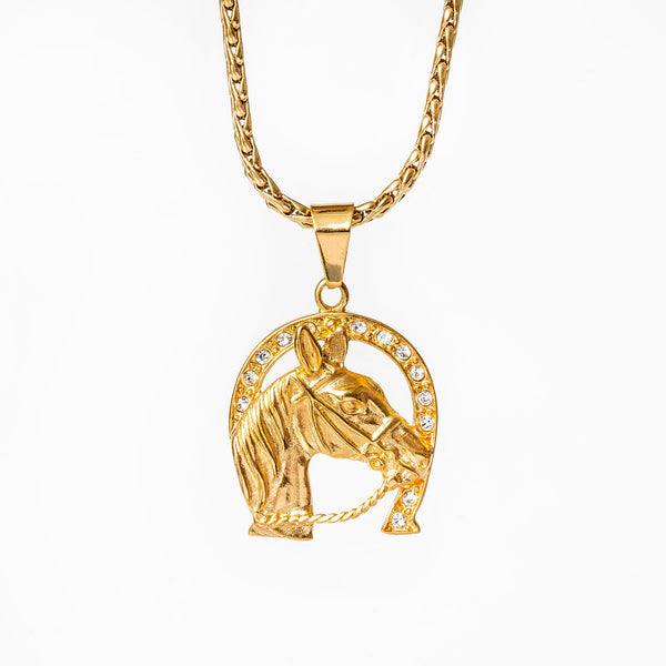 A Ta Ziemel gold-colored stainless steel necklace with a horse head pendant, accompanied by a chain.