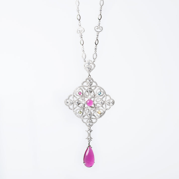 Tamara necklace with a geometric-patterned pendant featuring multicolored gemstones and a single pearl-like bead.