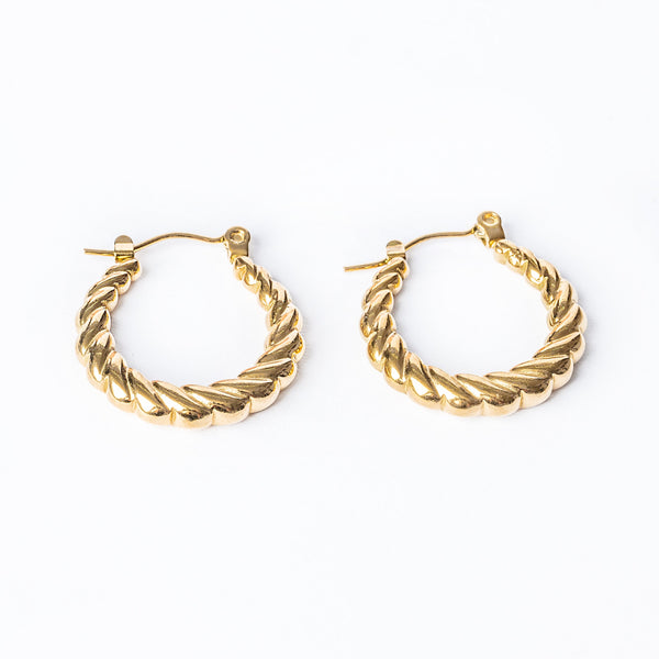 A pair of gold-colored stainless steel hoop earrings with a twisted design, displayed against a white background.