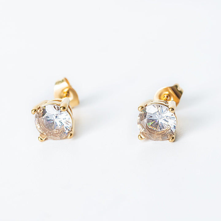 Gold Tessa stud earrings with round clear gemstones in a classic prong setting.