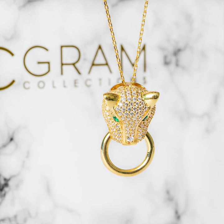 Close up of Chleo Necklace staying in front of its box, seen in the background. 