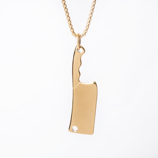 A gold-plated stainless steel Chef necklace in the shape of a chef's knife with a matching gold-plated chain.