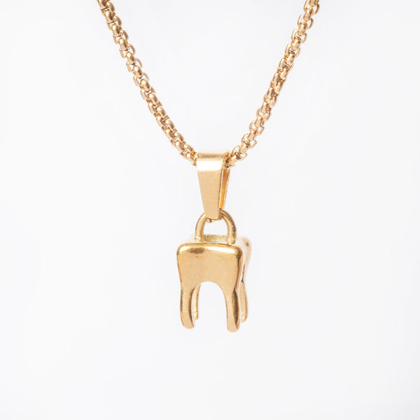 A gold-colored stainless steel tooth-shaped pendant necklace on a white background