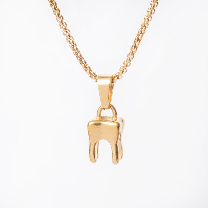 A gold-colored stainless steel tooth-shaped pendant necklace on a white background