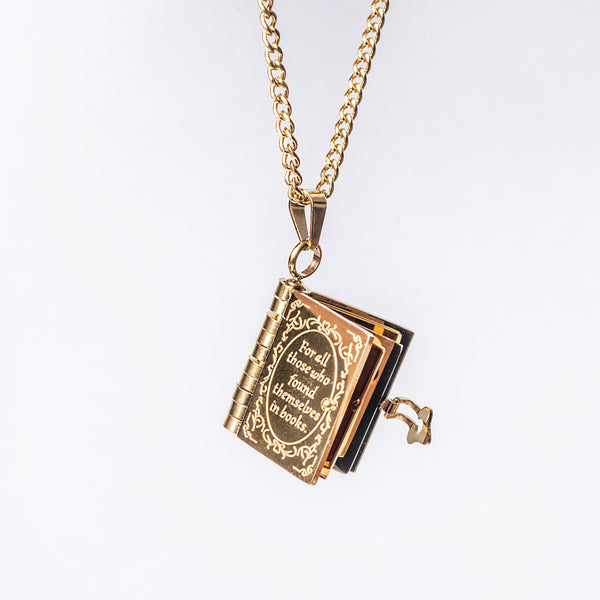 A gold-plated stainless steel necklace with a pendant book charm and a chain.
