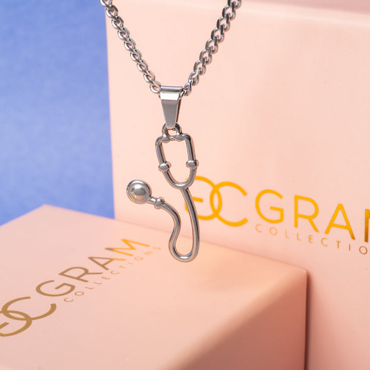 The Health Necklace standing in the center of the image in front of its uniquely designed pink box, standing in the blue background. 