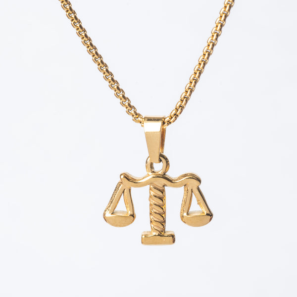 A gold-plated stainless steel Lawyer necklace with a pendant in the shape of a scale, representing the law or balance, on a white background.