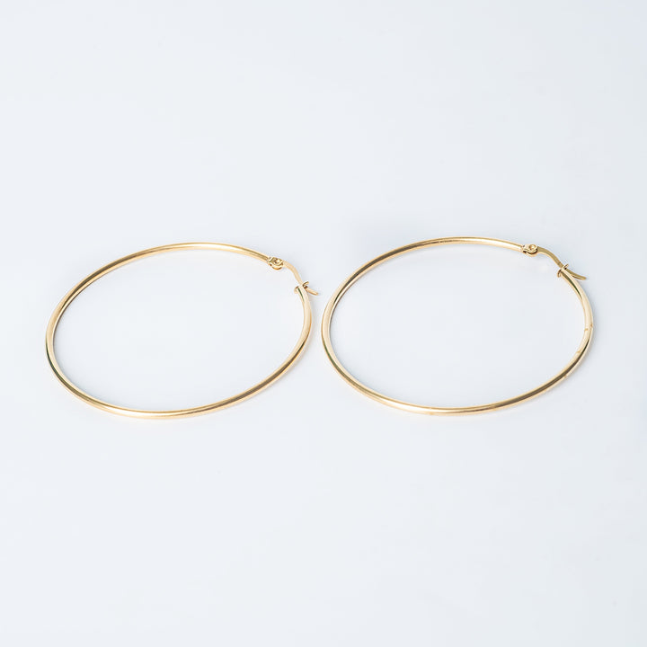 Gold Maya hoop earrings displayed flat on a white background