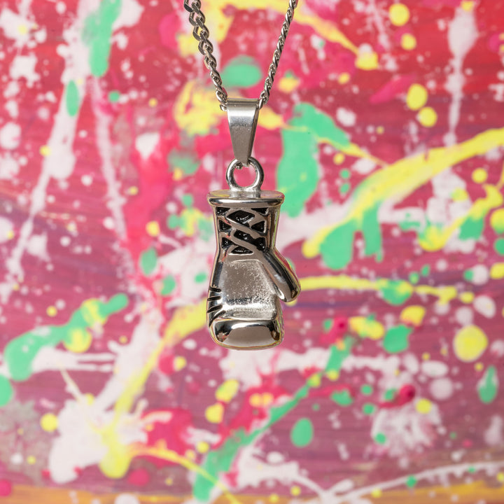 The Boxer Necklace standing in front of colorful background consist of red , yellow, pink and green background. 