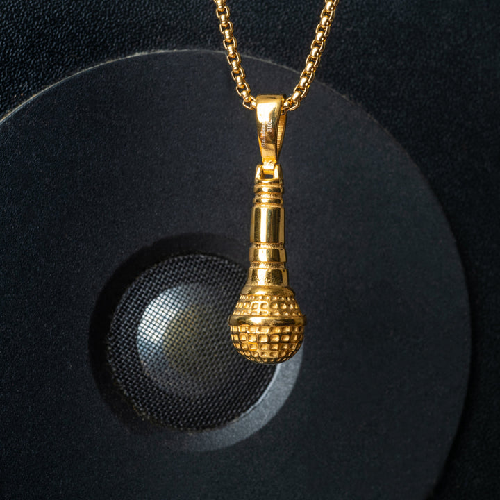 The gold colour singer necklace standing in the center of the image, in front of the sound system, symbolically representing music. 