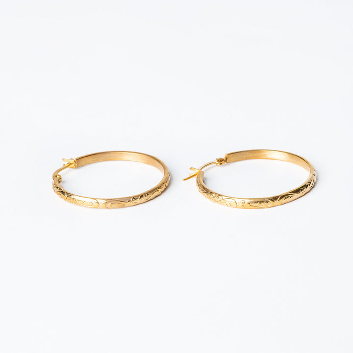 The sue earrings standing next to each other in horizontal position against a white background. 