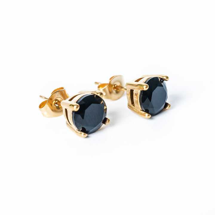 A close up view ofTommy Black Earrings from their profile side. 