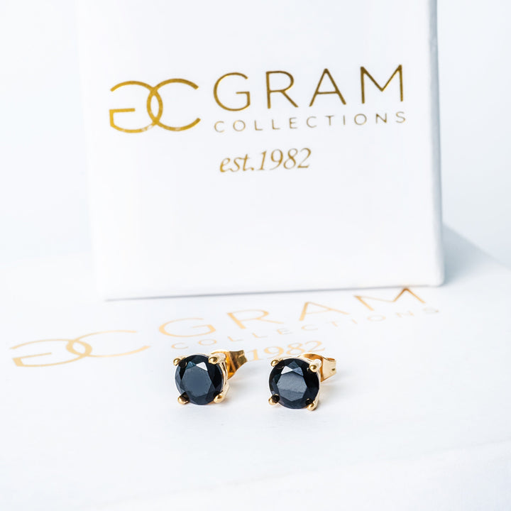 Tommy Black Earrings standing on its box 