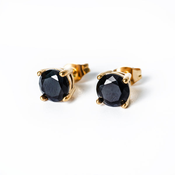 A close up view of Tommy Black Earrings standing against a white background 