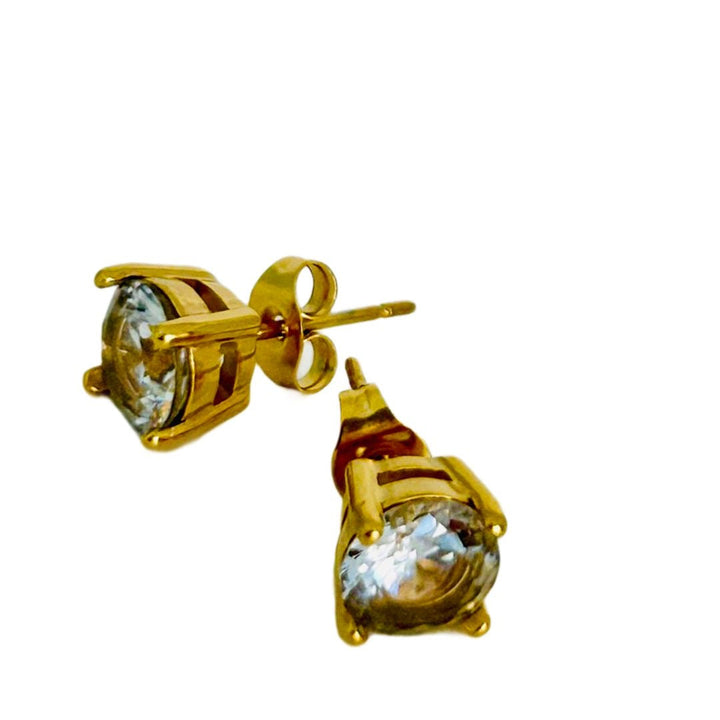A close up view of tommy earrings standing in the center of the image. 