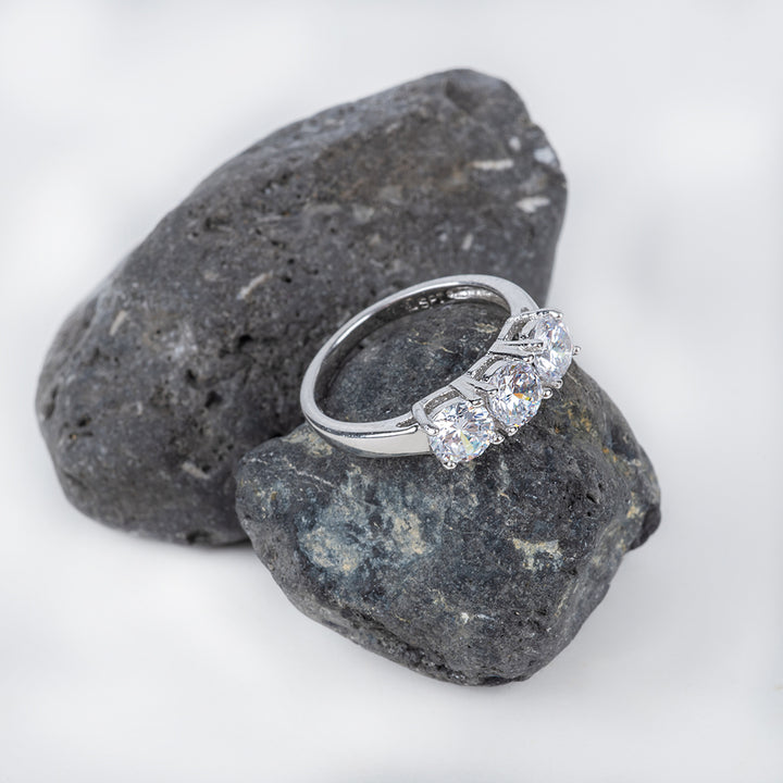 Trilogy Ring placed on the dark grey stone, placed in the center of the image against a white background. 