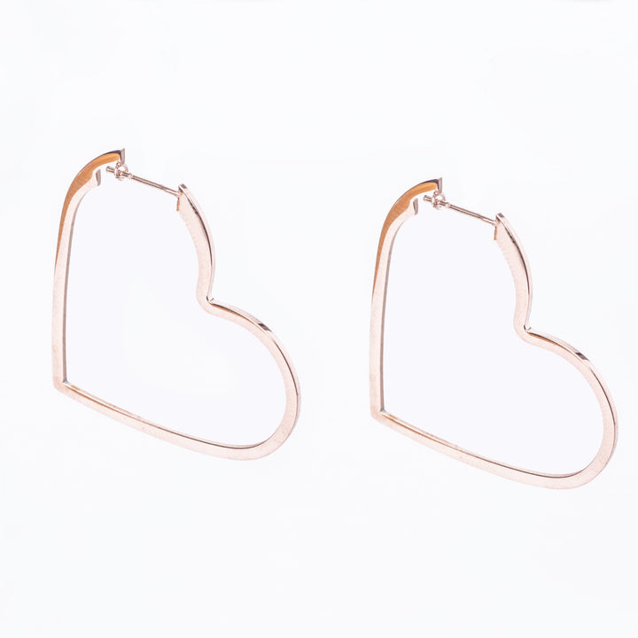 A pair of rose gold-colored heart-shaped hoop earrings on a white background