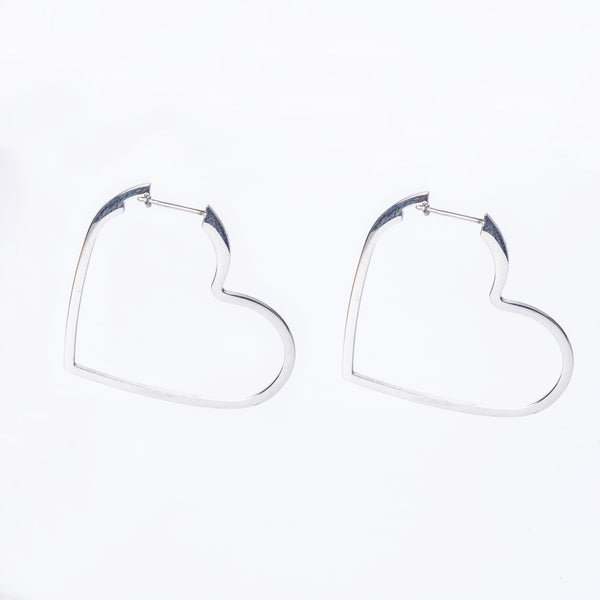 A pair of silver Valentina hoop earrings designed in the shape of hearts.