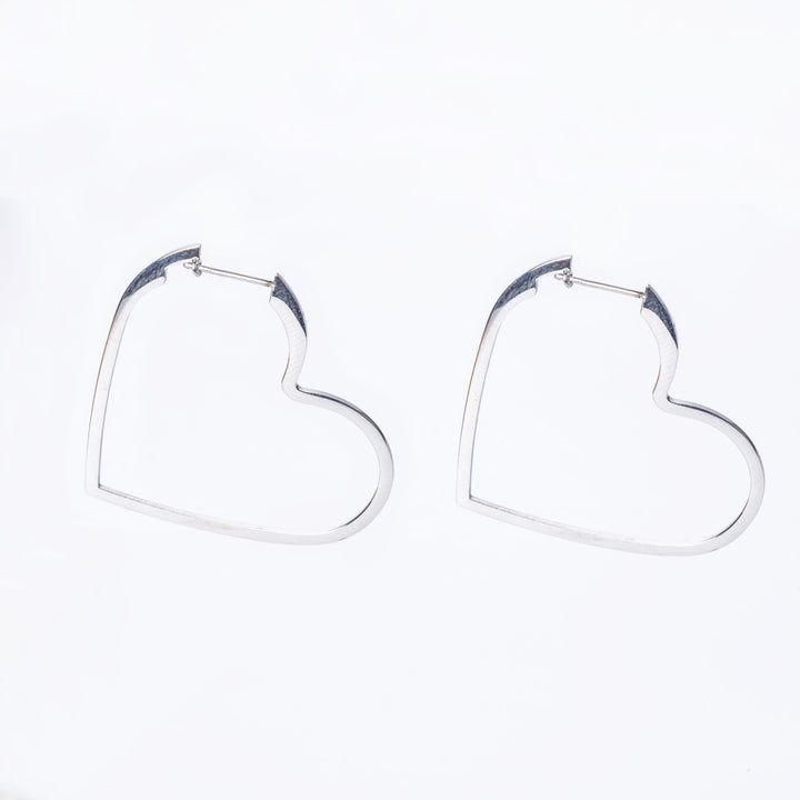 A pair of silver Valentina hoop earrings designed in the shape of hearts.