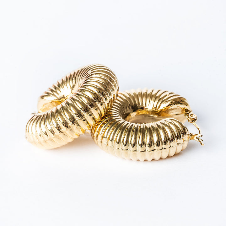 A close up view of Valerie earrings standing in the center of the image against a white background. 