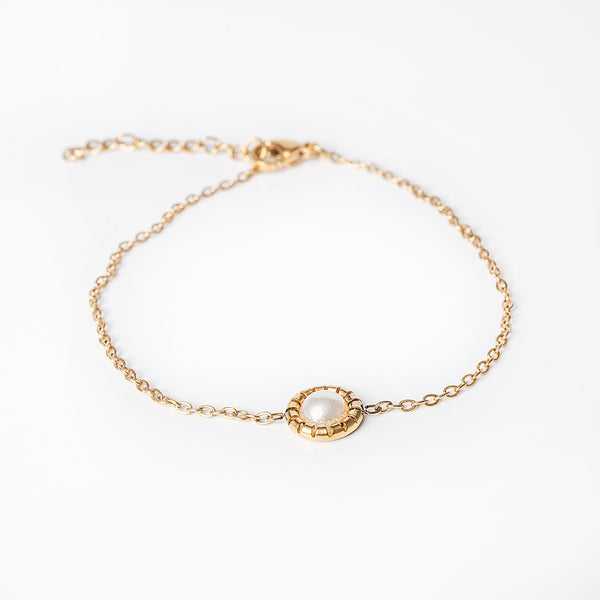 A gold-plated stainless steel bracelet with a cultured pearl accent, displayed against a white background.