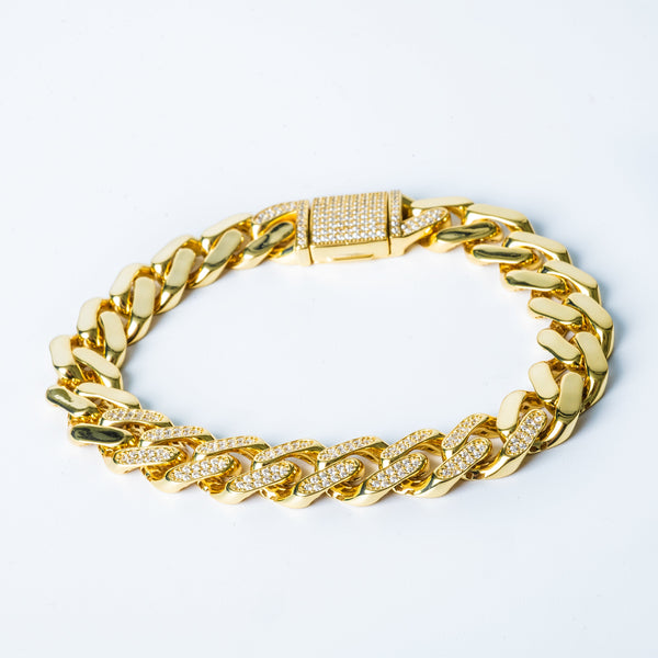 A yellow gold-colored Viebracelet with diamond encrusted ends on a white background.na 