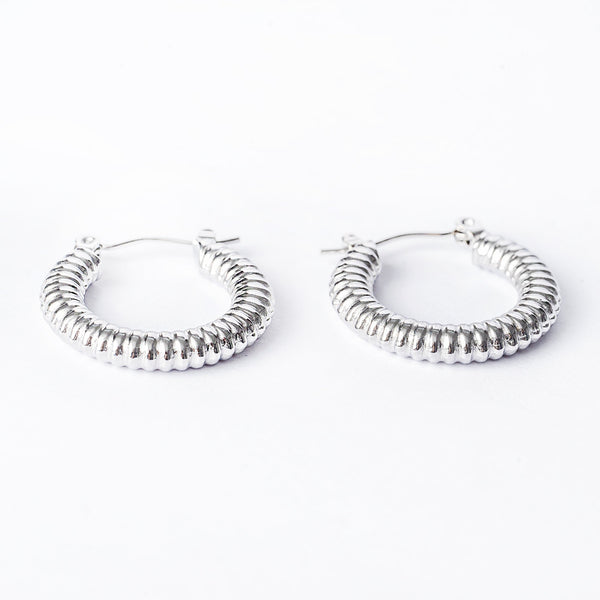 A pair of silver hoop Vivi earrings with a textured surface on a white background.