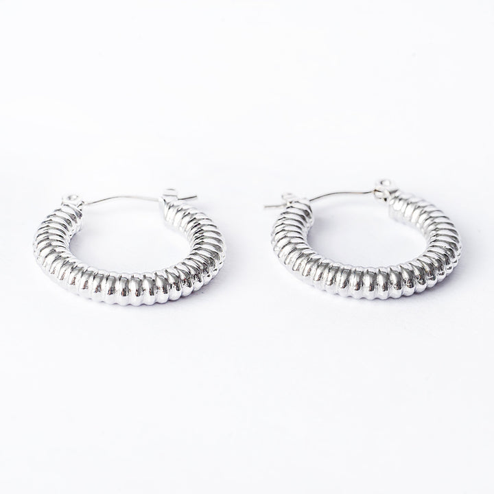 A pair of silver hoop Vivi earrings with a textured surface on a white background.