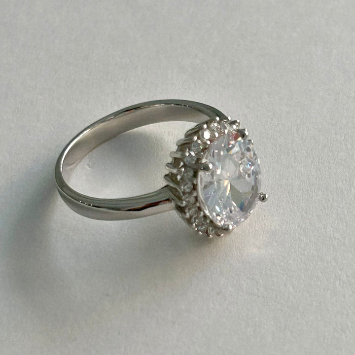 A close up view of Kate Ring standing in the ceter of the image against a white surface. 